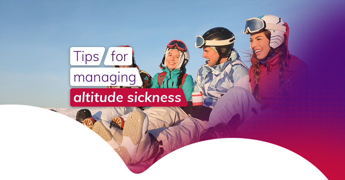 A group of friends sitting atop a snowy mountain, wearing ski gear and laughing together