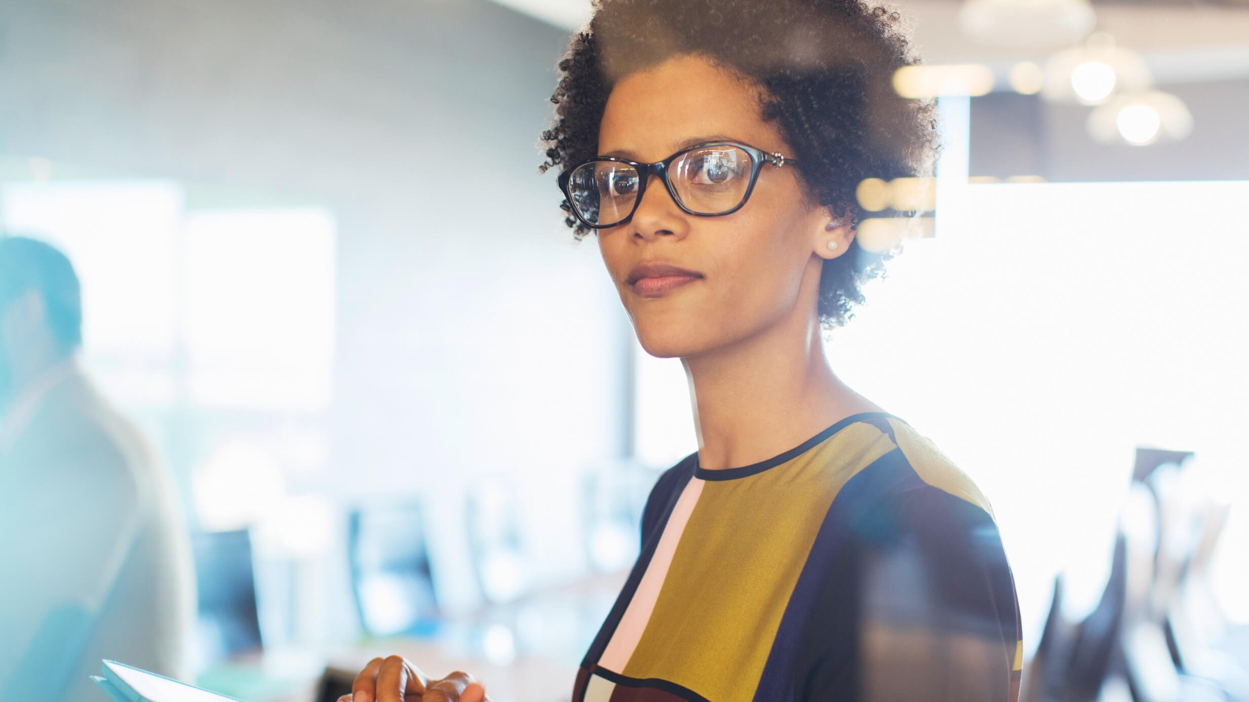 Woman with glasses holding ipad at work