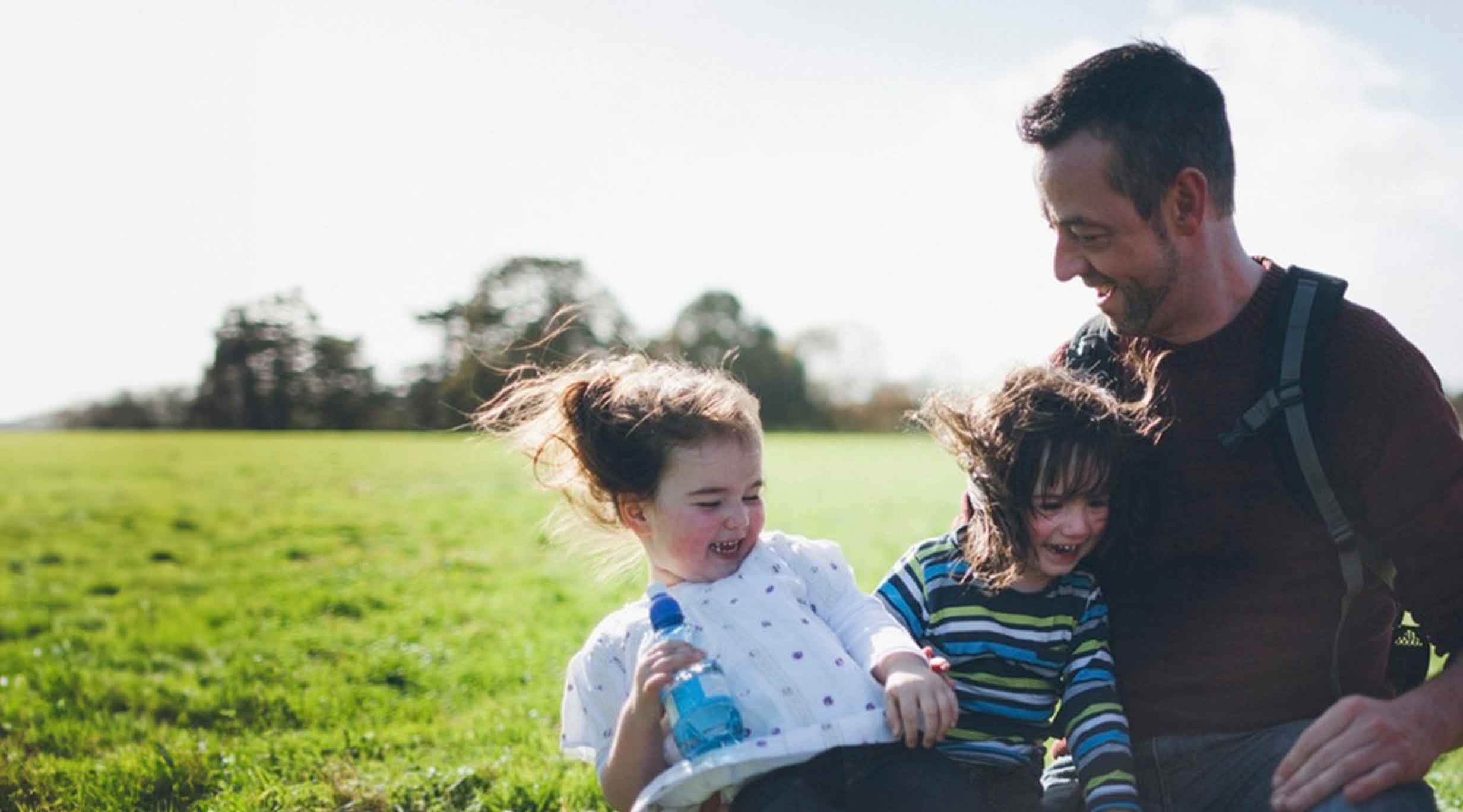 A father with two children in a park