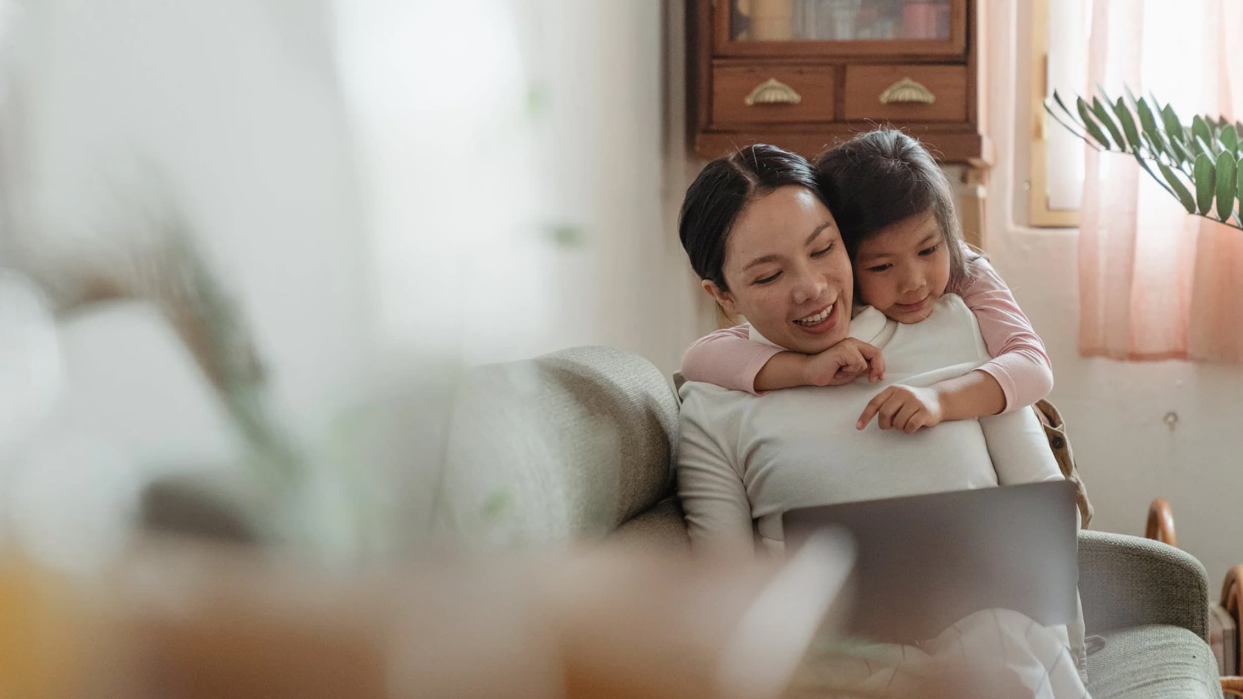 Mother and daughter looking into laptop