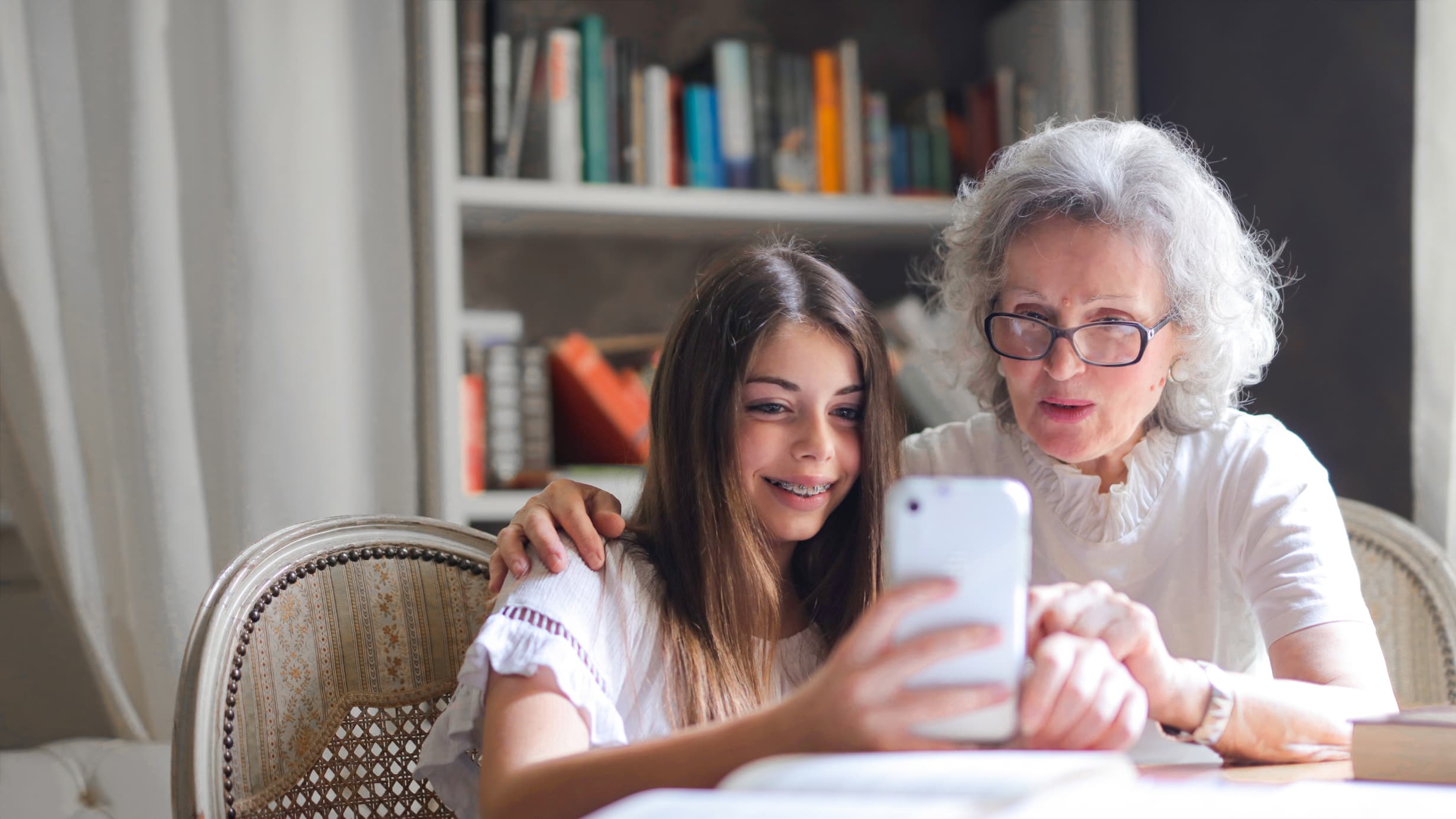 Genetic testing, grandmother and granddaughter looking at mobile phone