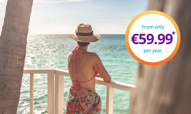 Woman standing by railings, looking out at the ocean